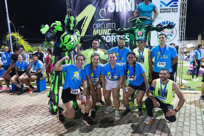 Grupo de atletas com os robôs no painel das marcas.