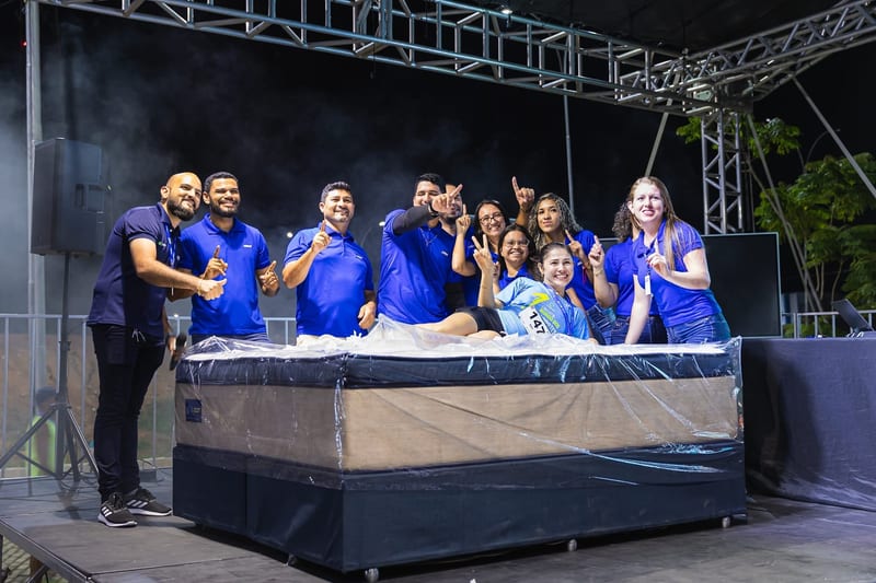A equipe da Gazin no palco com a ganhadora do sorteio.